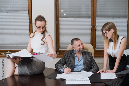 Fotografie Businessman and his assistants secretaries in his office.