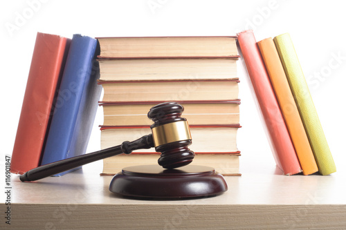 Law concept - Book with wooden judges gavel on table in a courtroom or enforcement office.