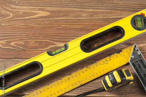 Set of tools at wooden table. meter measuring line construction level and square ruler maintenance concept