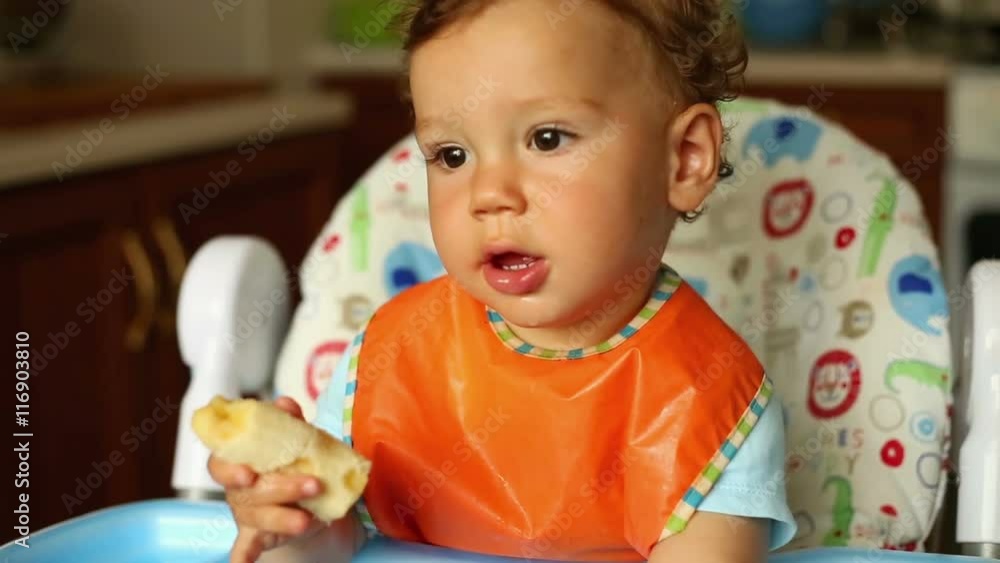 Baby is eating a banana in the kitchen
Baby is eating a banana in the kitchen