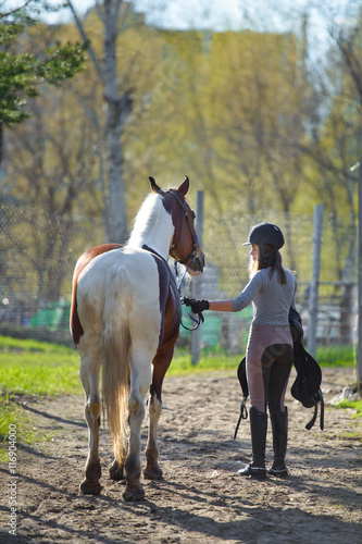 Girl sportswoman and her horse back to the stables after riding © sheikoevgeniya
