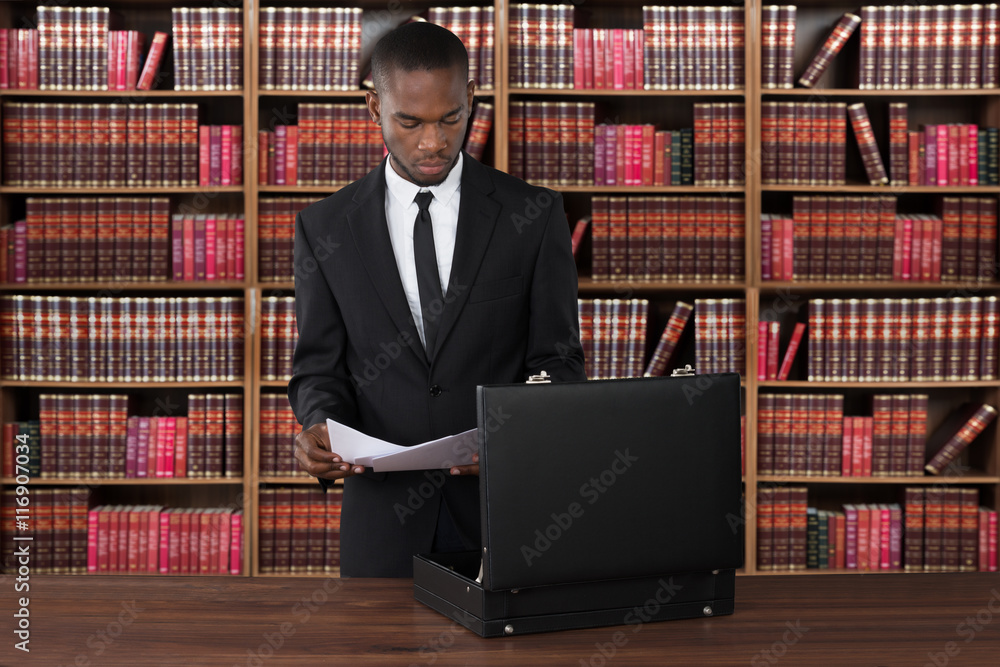Lawyer With Papers And Briefcase At Desk