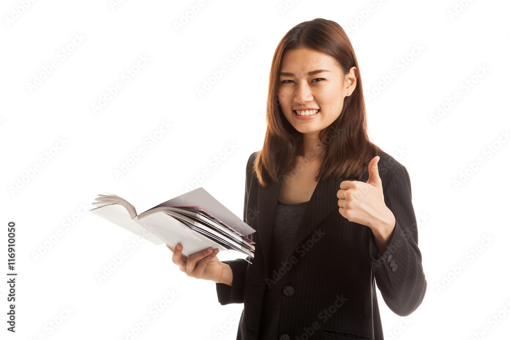 Young Asian business woman thumbs up with a book. Young Asian business woman thumbs up with a book.