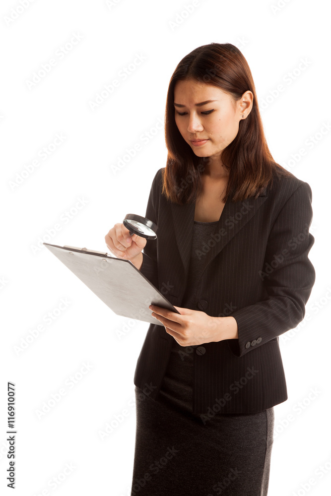 Young Asian business woman with a magnifying glass check report. Young Asian business woman with a magnifying glass check report.