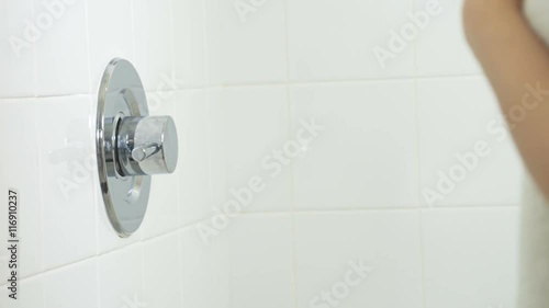 Woman turns on the shower.