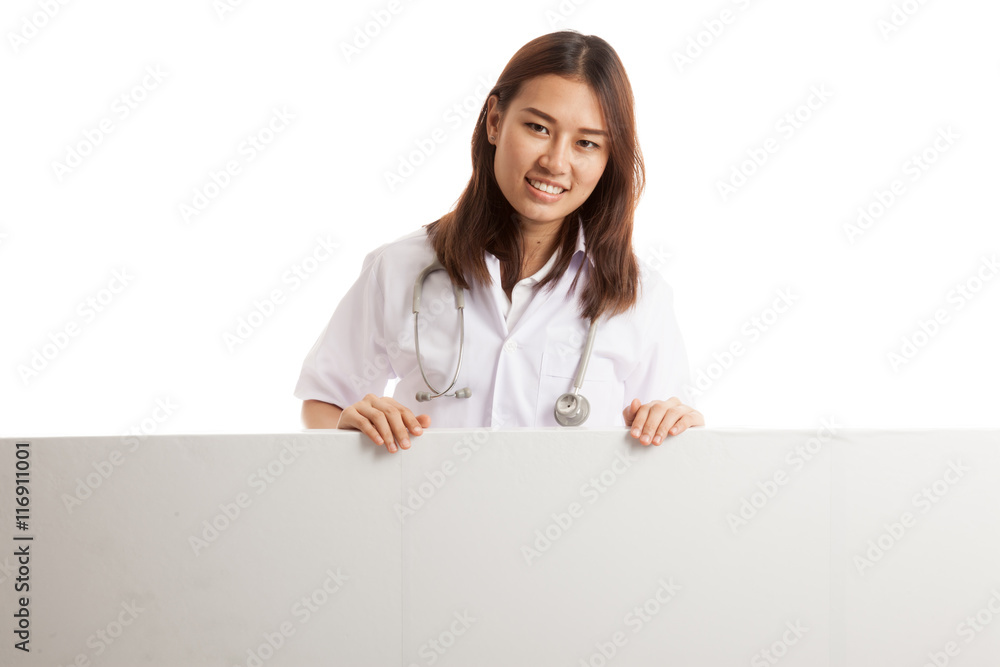 Young Asian female doctor show thumbs up behind blank white bil Young Asian female doctor show thumbs up behind blank white bil