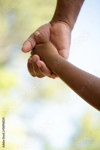 Rear view of father and son holding hands. © digitalskillet1
