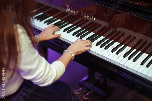Woman with delicate hands plays a piano © IVASHstudio