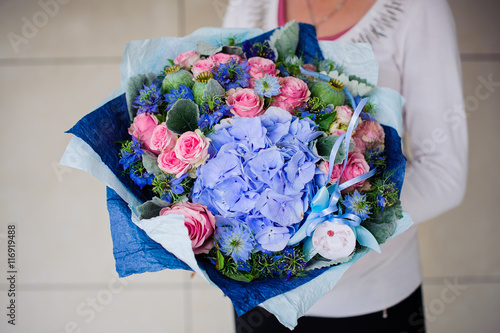 Bouquet of white and blue flower in hands photo