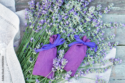 Fototapeta Naklejka Na Ścianę i Meble -  Bouquet of lavender with linen aroma sack on wooden table 