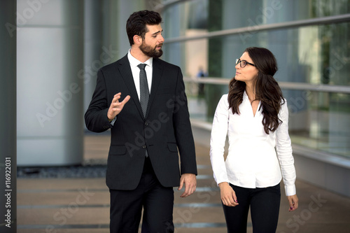 Coworkers walk at workplace business CEO boss and assistant talk strategy