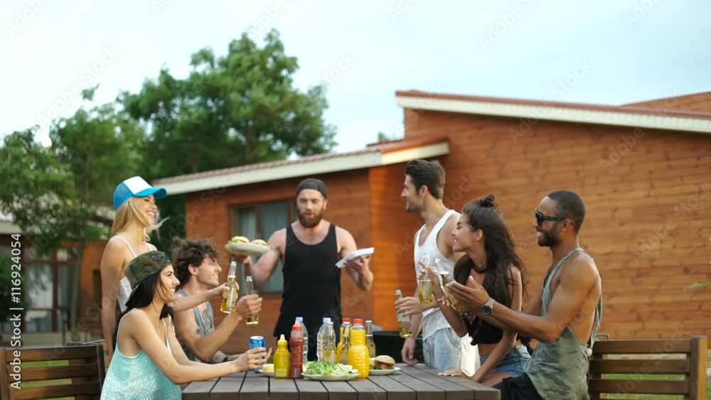 Group of young beautiful happy people eating and drinking at the picnic area Group of young beautiful happy people eating and drinking at the picnic area