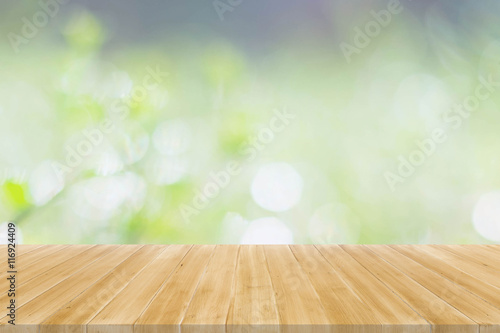 Wood table top on green bokeh abstract background - display your products