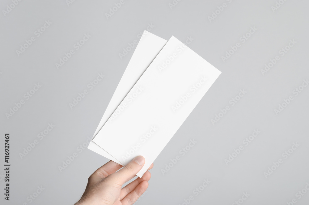 Dl Flyer Mock-Up - Male hands holding blank flyers on a gray background. Dl Flyer Mock-Up - Male hands holding blank flyers on a gray background.