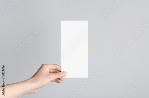 Dl Flyer Mock-Up - Male hands holding a blank flyer on a gray background.