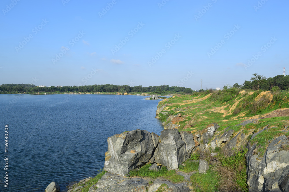 rocky lake with some stones and grass in the bank