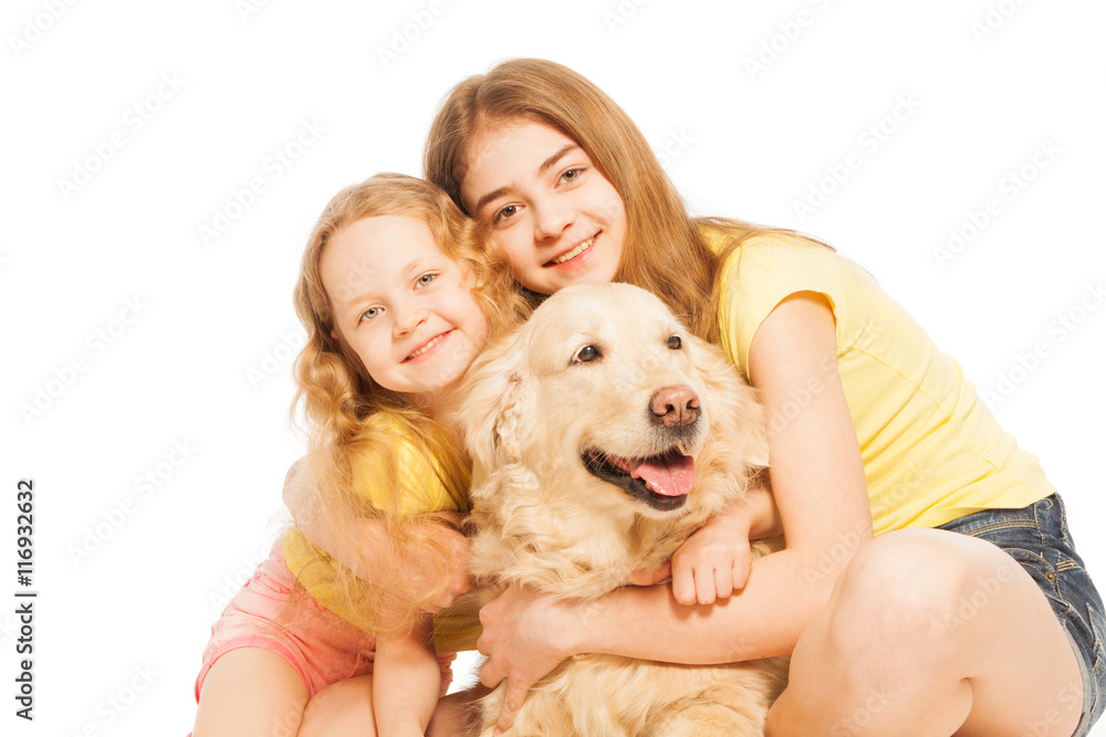 Two blond girls hugging their Golden Retriever Two blond girls hugging their Golden Retriever