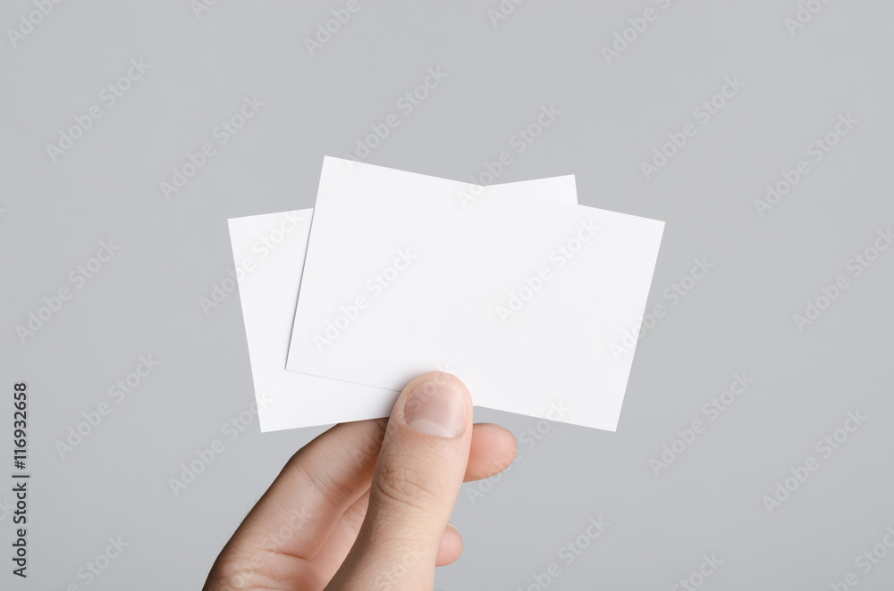 Business Card Mock-Up (85x55mm) - Male hands holding blank cards on a gray background. Business Card Mock-Up (85x55mm) - Male hands holding blank cards on a gray background.