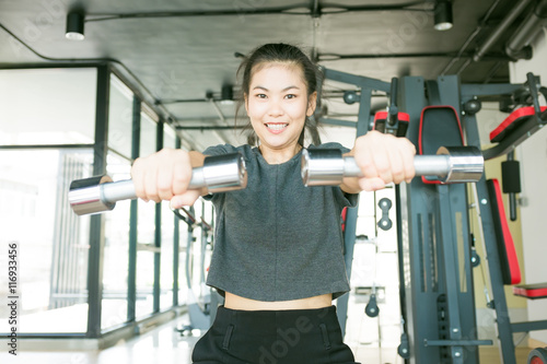 Woman lifting dumbell for sport body strong and beautiful