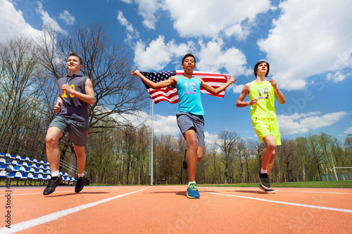 Winning runners with USA flag celebrating victory © Sergey Novikov