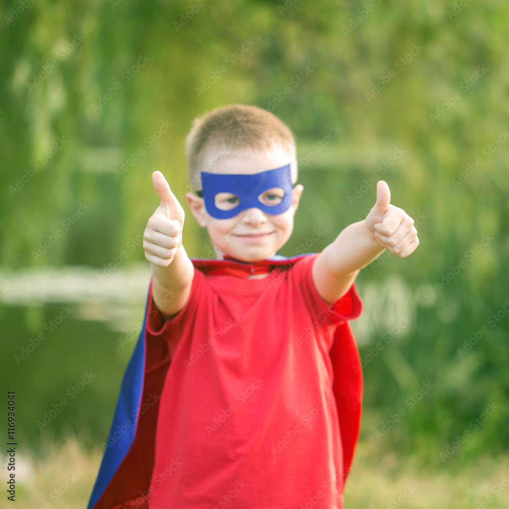 Kid in super hero costume showing thumbs up. Kid in super hero costume showing thumbs up.