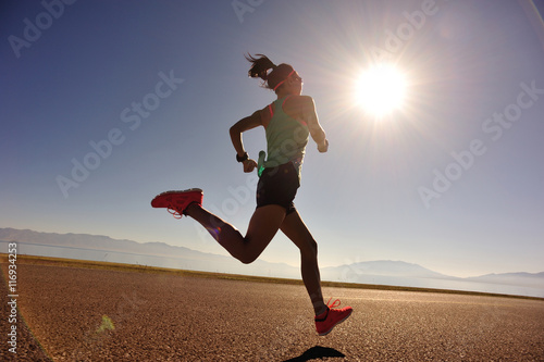  young fitness woman runner running on sunrise seaside trail