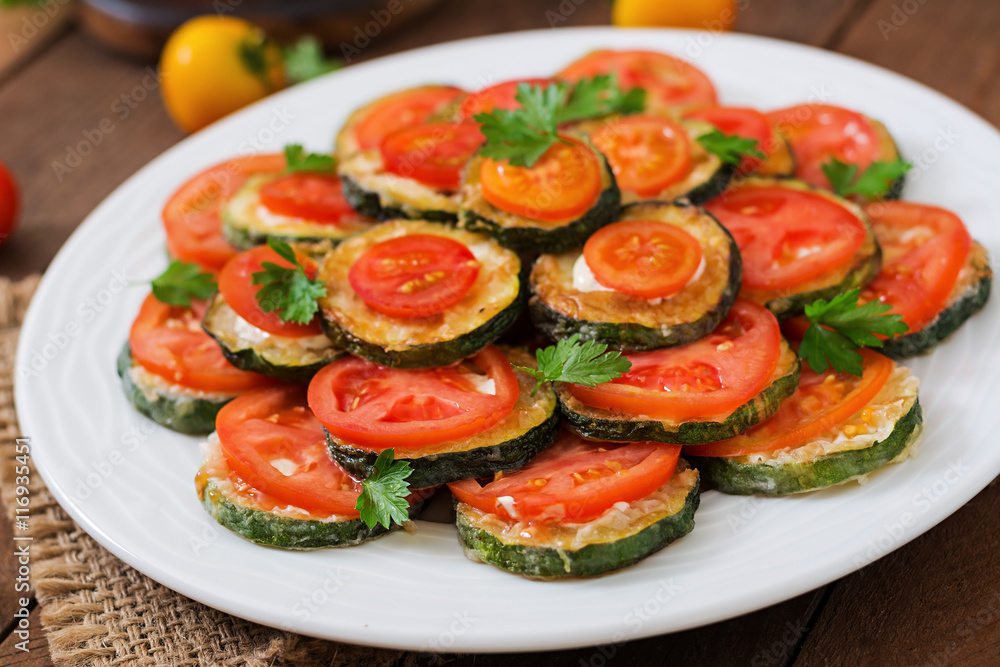 Dish with a snack of fried zucchini with tomatoes Dish with a snack of fried zucchini with tomatoes