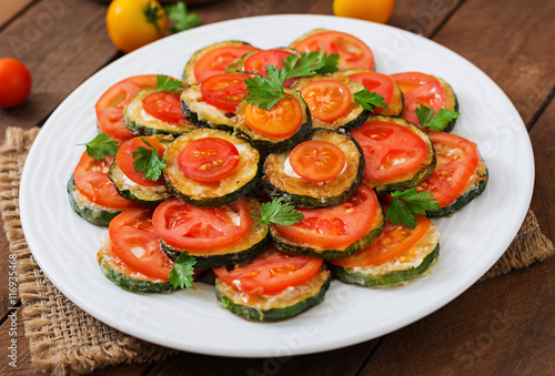 Dish with a snack of fried zucchini with tomatoes