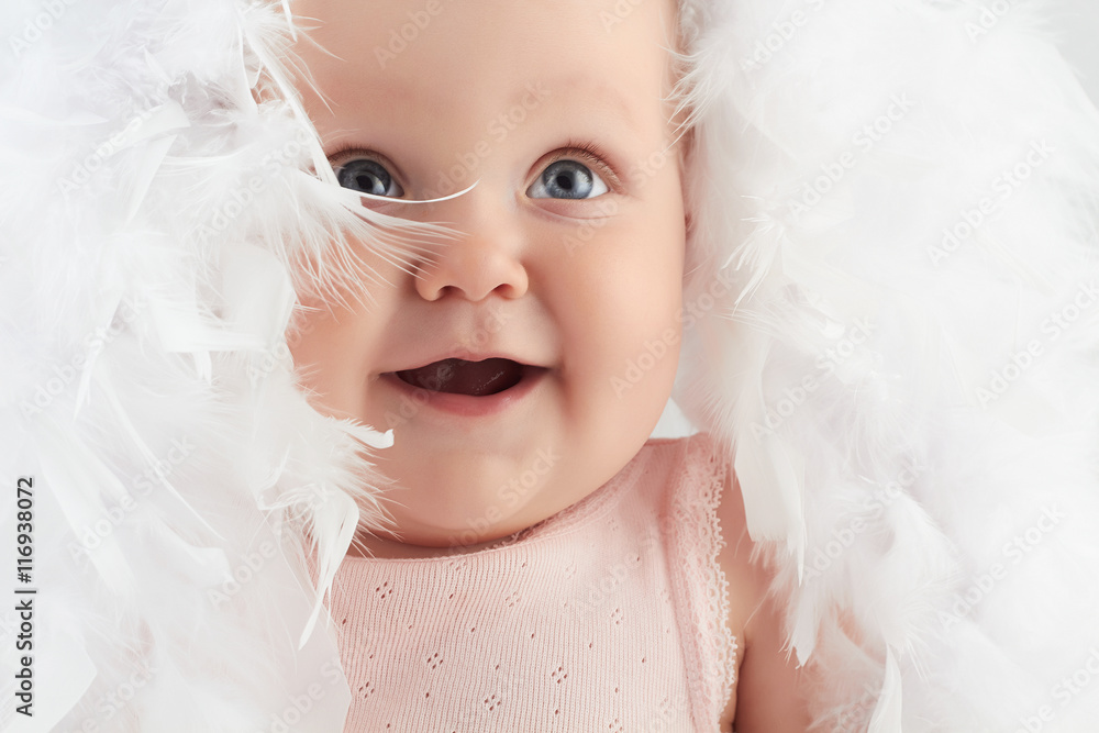 smiling baby girl in feathers. little funny child.newborn smiling baby girl in feathers. little funny child.newborn