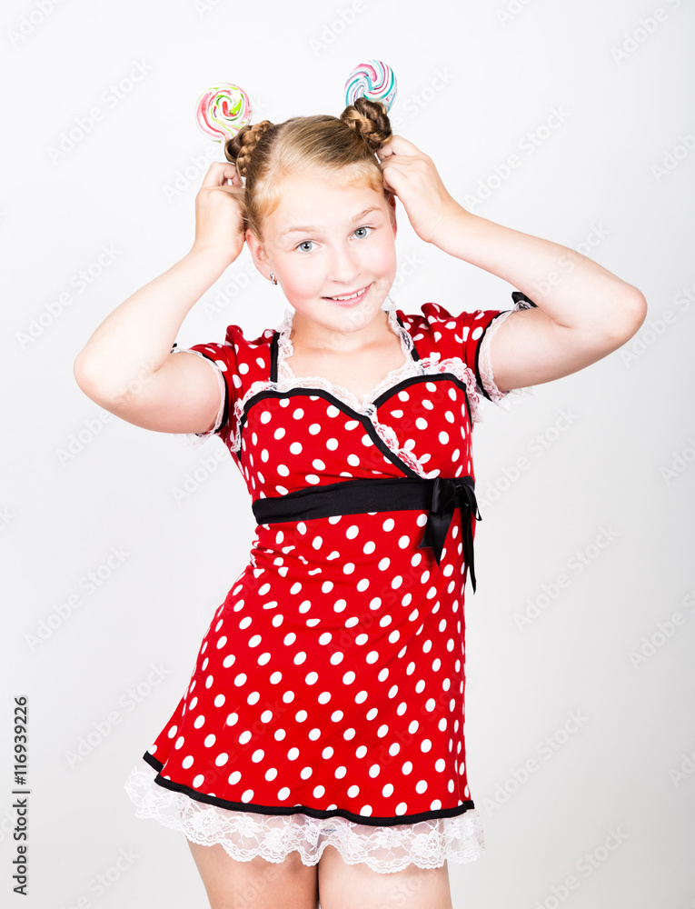 Portrait of happy beautiful young girl with sweet candys. pretty young woman dressed in a red dress with white polka dots holding two colorful lollipop Portrait of happy beautiful young girl with sweet candys. pretty young woman dressed in a red dress with white polka dots holding two colorful lollipop