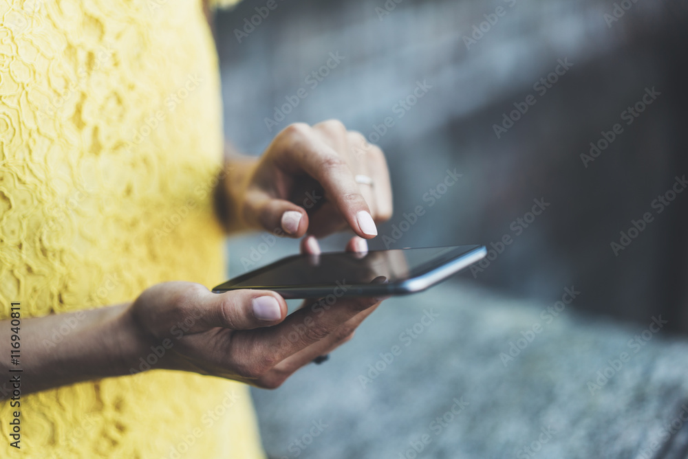 Close-up image of female hands typing on touch screen of modern smartphone, young hipster girl sending an sms message via cellphone, social networking concept, film effects