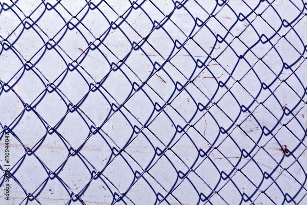 Fototapeta premium abstract chain link fence texture against grungy color wall.