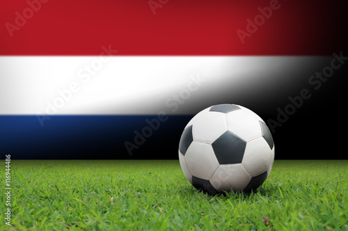 vintage black and white football ball on green grass has the national flag of thailand background