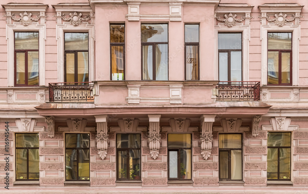 Several windows in a row and bay window on facade of urban apartment building front view, St. Petersburg, Russia.