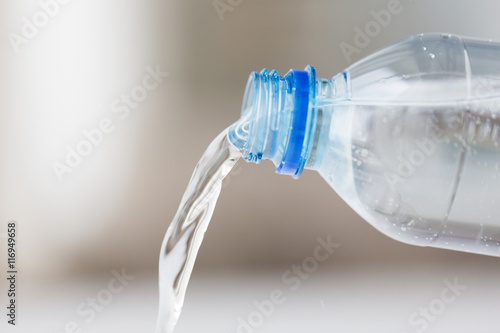 close up of water pouring from plastic bottle