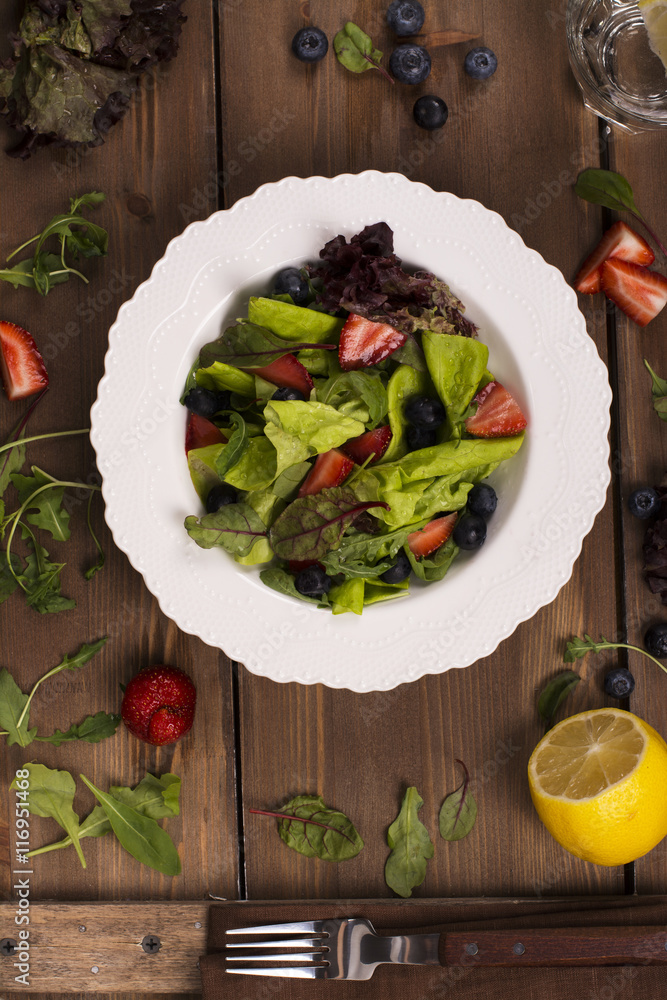 Fresh summer salad with berries and green leaves