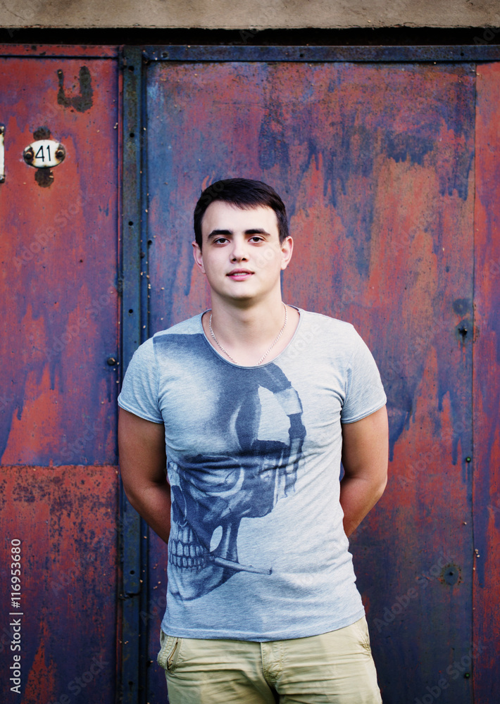 Fototapeta premium young happy man against rusty metal wall