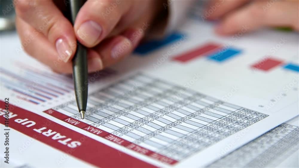 Woman Hand Checks Start Up Report. Close Up Woman Hand Checks Start Up Report. Close Up