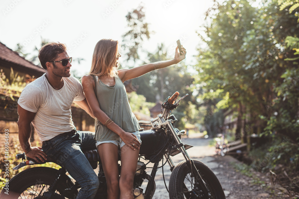 Young couple taking selfie on motorcycle