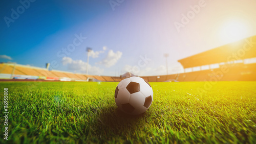 Konstfotografi Soccer ball on the grass grass in soccer stadium , sunset..