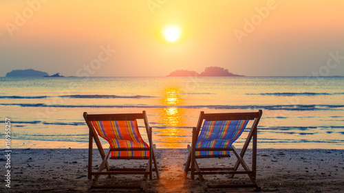 Pair of beach loungers on the deserted beach at sunset.