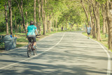Woman biking park in Bangkok, Thailand. Cycling Fitness in public park.

