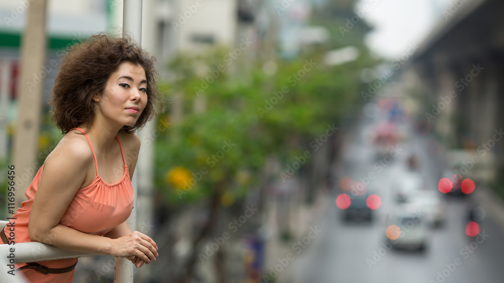 Asian girl portrait in a big city, the background blurred track.
