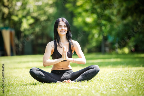 Happy young girl practicing yoga outdoors