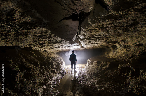 caver silhouette in dark cave