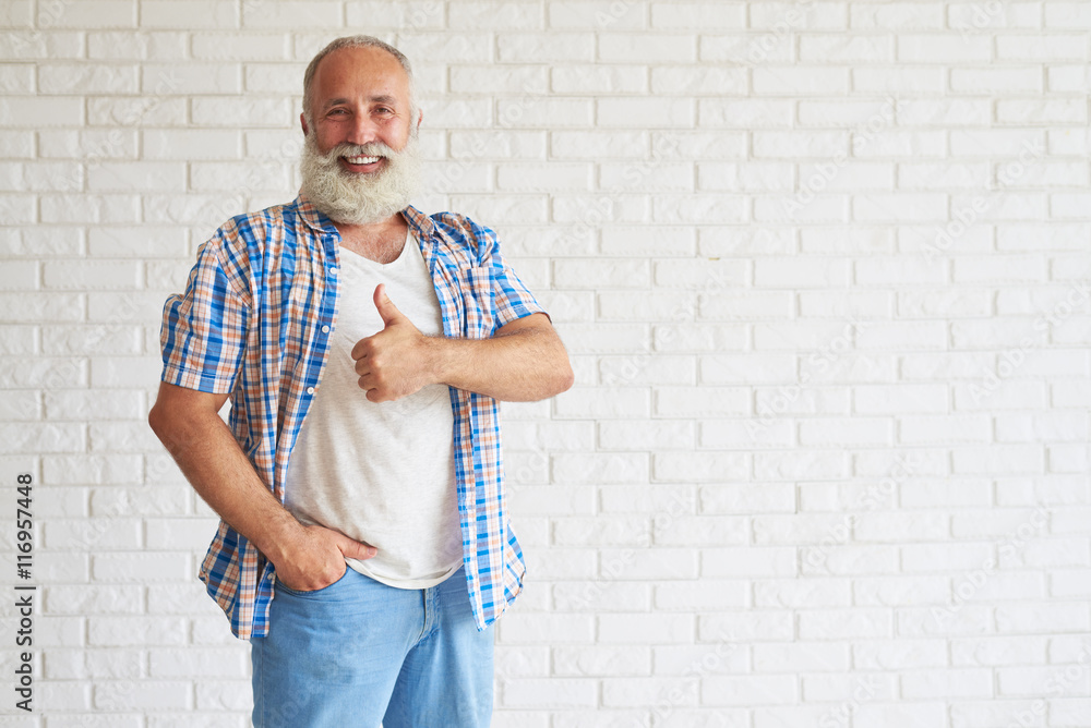 Happy senior is standing and holding thumbs up Happy senior is standing and holding thumbs up