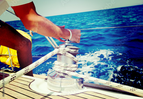 Fototapeta Sailing crew member pulling rope on sailboat