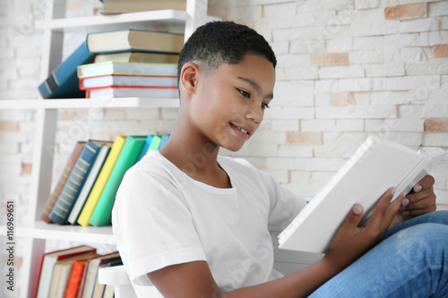 African American boy readin...