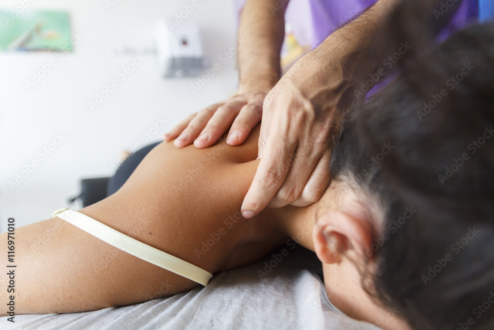 Fisioterapeuta trabajando los hombros de una joven deportista. Quiromasajista terapéutico trabajando. Tratamiento de sobrecarga muscular. Fisioterapeuta trabajando los hombros de una joven deportista. Quiromasajista terapéutico trabajando. Tratamiento de sobrecarga muscular.