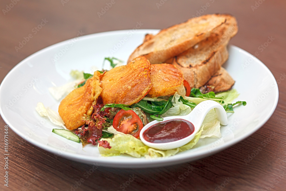 Potato pancakes with vegetable salad and homemade bread. Potato pancakes with vegetable salad and homemade bread.